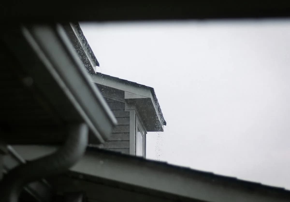 Seamless gutter run along a roofline in the rain