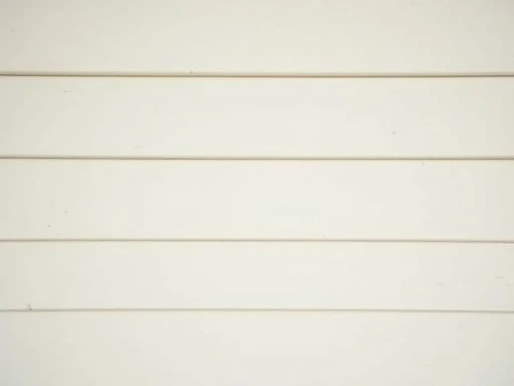 Clean white lap siding against a blue sky